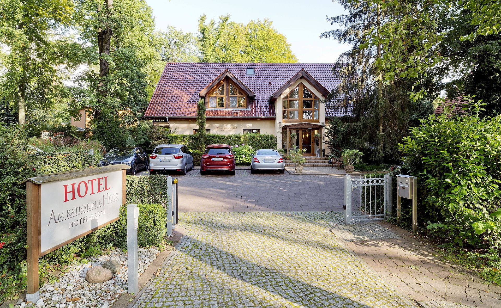 Hotelgarten mit alten Eichen und Liegestühlen auf gepflegtem Rasen – Hotel Potsdam Katharinenholz